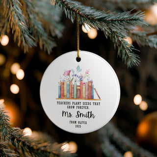 Round ornament with book design and text hanging on a Christmas tree.
