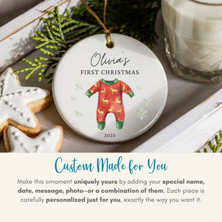 Personalized Christmas ornament with a baby onesie design, placed on a festive surface with cookies and milk.