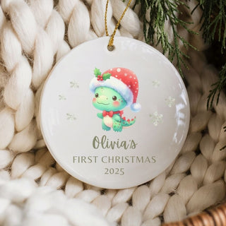 Christmas ornament with a baby dinosaur wearing a Santa hat on a textured surface.