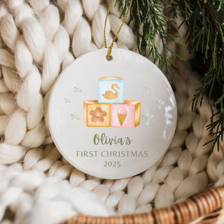 Personalized baby’s first Christmas ornament with watercolor baby toys design, custom ceramic keepsake with baby name and birth details.