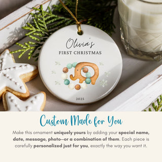 Personalized Christmas ornament with elephant design and text 'Olivia's First Christmas 2023' on a festive background.
