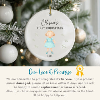 Personalized Christmas ornament for 'Olivia's First Christmas' on a decorated tree with 'Our Love it Promise' text below.