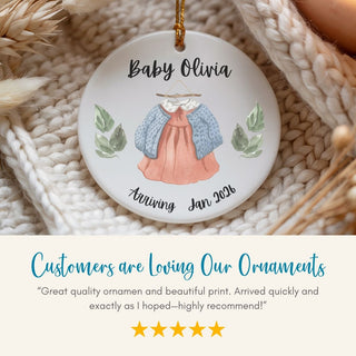 Personalized baby ornament with clothing illustration and text on a textured surface
