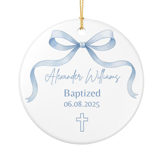Round ornament with pastel ribbon bow and small cross, customizable with baby name and baptism date; elegant christening keepsake for godparents or family.